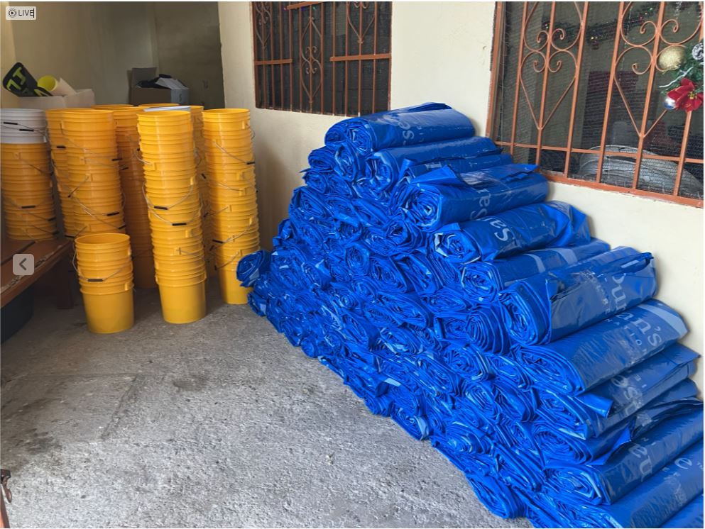 blue rolled tarps and stacks of yellow buckets, about 60 of each.